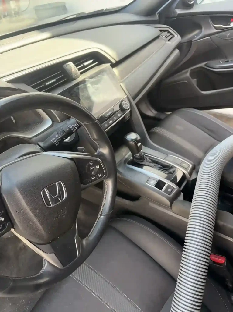 Front car Dashboard and seat with a visible stain and dusty dashboard before cleaning